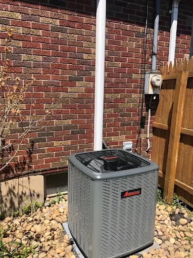Amana air conditioner installation beside a brick home
