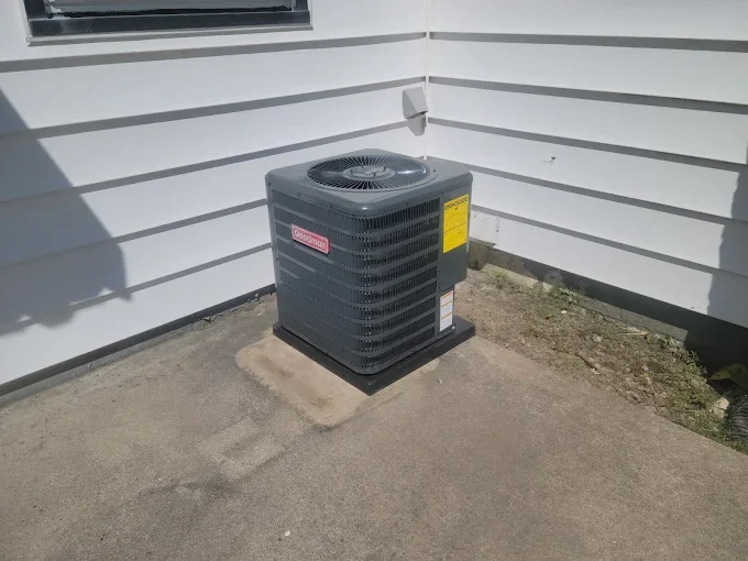 New Goodman air conditioner installed on a concrete pad